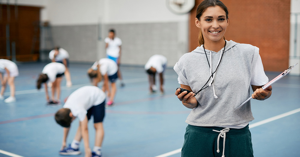Kinesology coach with students in a gym
